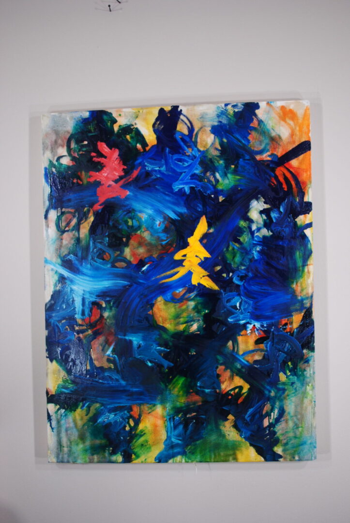 A painting of blue and yellow swirls on paper.